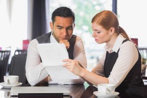 Serious business team working together in a cafe and going over documents