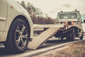 Loading broken car on a tow truck on a roadside